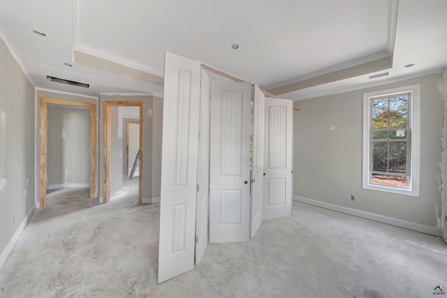 unfurnished bedroom featuring a raised ceiling and ornamental molding