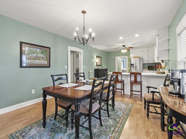 dining room featuring light hardwood / wood-style flooring and ceiling fan with notable chandelier