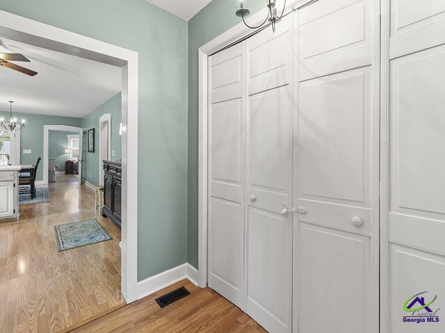 hallway with a chandelier and light hardwood / wood-style flooring