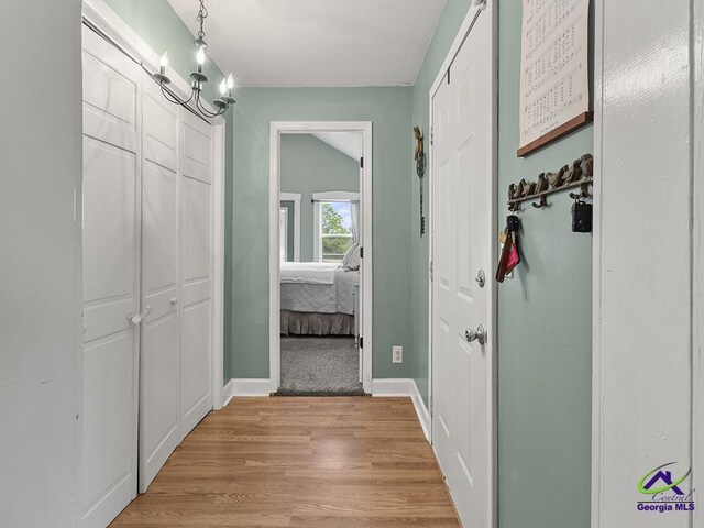 hallway featuring a chandelier and light hardwood / wood-style floors