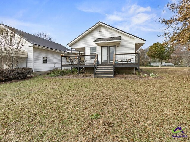 back of house with a lawn and a wooden deck