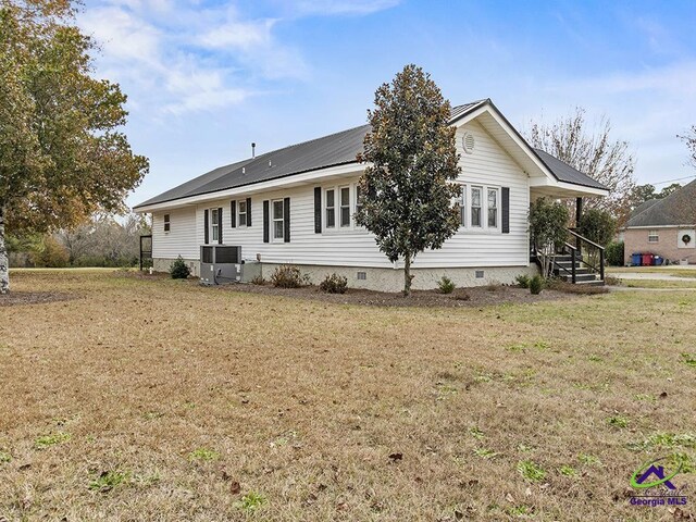 view of front of property with central AC and a front yard