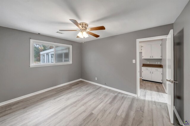 empty room featuring ceiling fan and light hardwood / wood-style floors