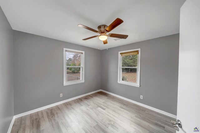 spare room with ceiling fan and light wood-type flooring