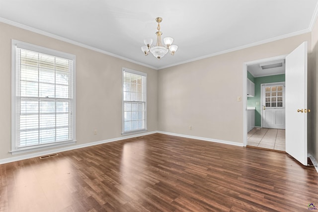 empty room featuring crown molding, dark hardwood / wood-style floors, and an inviting chandelier