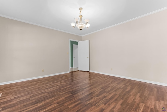 spare room featuring dark hardwood / wood-style floors, an inviting chandelier, and ornamental molding