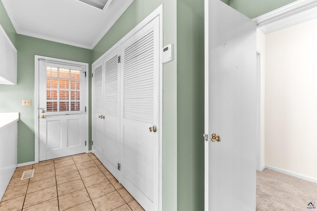 doorway featuring light tile patterned flooring and ornamental molding