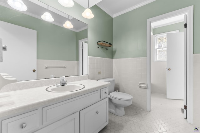 bathroom featuring vanity, crown molding, tile patterned flooring, toilet, and tile walls