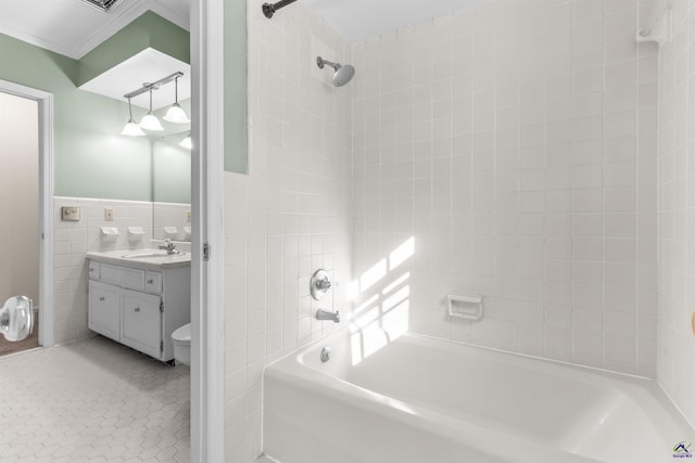 full bathroom featuring tile patterned flooring, toilet, vanity, tile walls, and tiled shower / bath