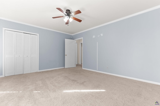 unfurnished bedroom featuring carpet flooring, ceiling fan, a closet, and ornamental molding