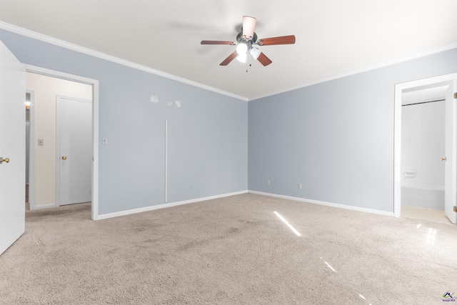 carpeted spare room with ceiling fan and ornamental molding