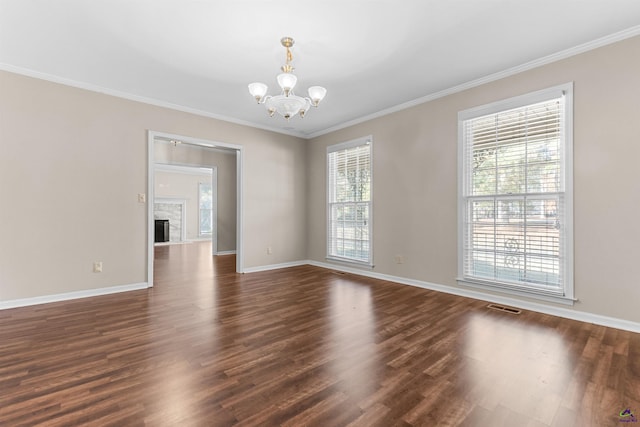 spare room with dark hardwood / wood-style flooring, ornamental molding, and an inviting chandelier