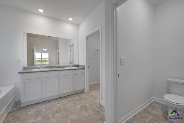 bathroom with vanity, a bathtub, and toilet