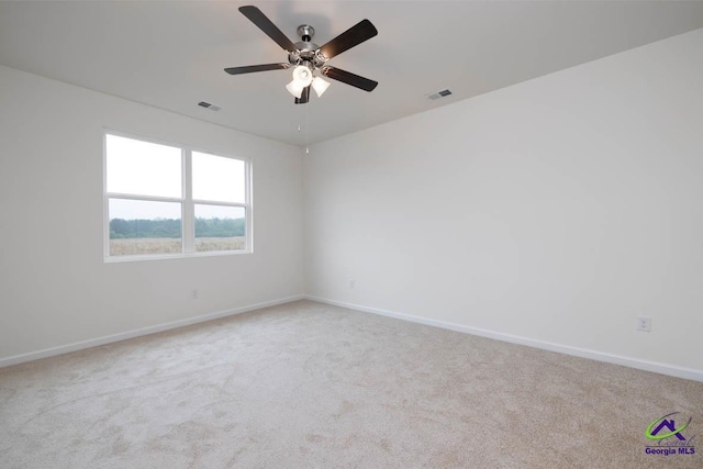 carpeted spare room featuring ceiling fan