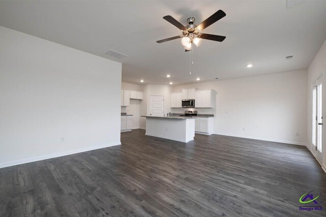 unfurnished living room with ceiling fan and dark wood-type flooring