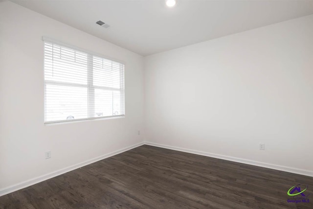 spare room with dark hardwood / wood-style floors