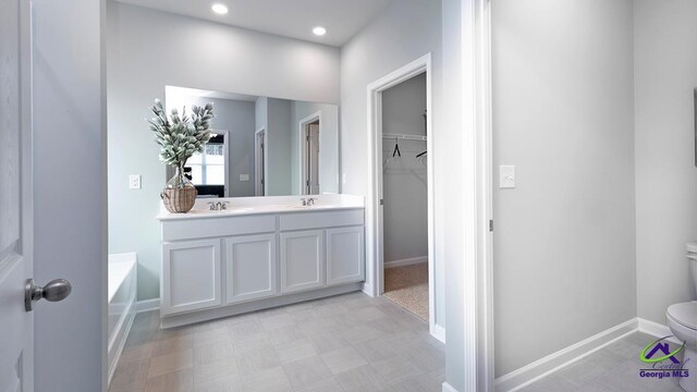 bathroom featuring vanity, a bath, and toilet