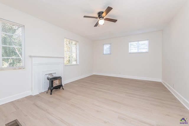 unfurnished living room with light wood-type flooring, ceiling fan, and a healthy amount of sunlight