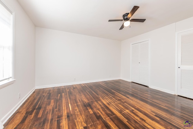 unfurnished bedroom with ceiling fan and dark wood-type flooring