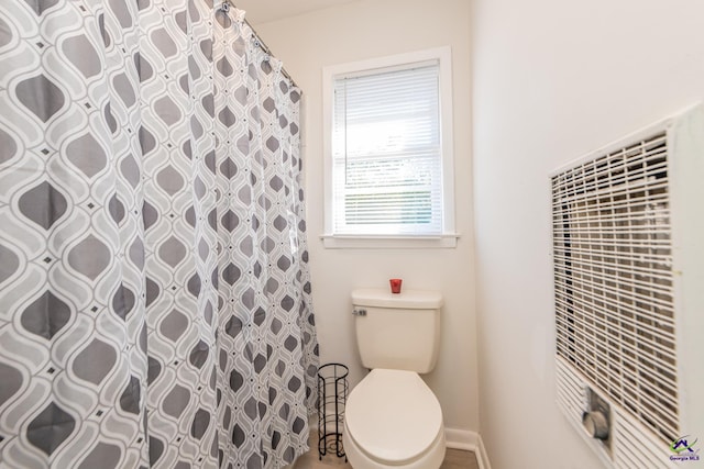 bathroom featuring a shower with curtain and toilet