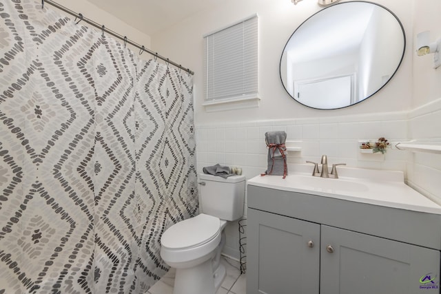 bathroom featuring vanity, toilet, and tile walls