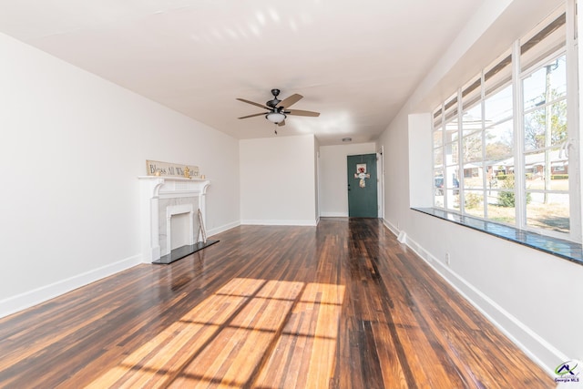 unfurnished living room with dark hardwood / wood-style floors and ceiling fan