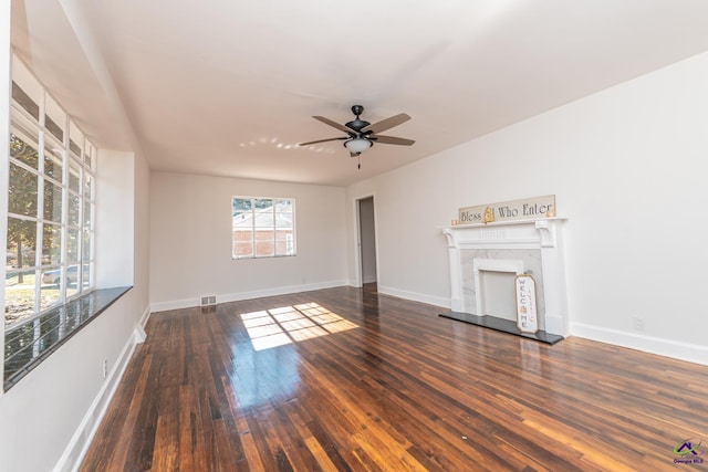 unfurnished living room with dark hardwood / wood-style flooring, ceiling fan, and a premium fireplace