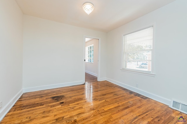 unfurnished room with wood-type flooring and a healthy amount of sunlight