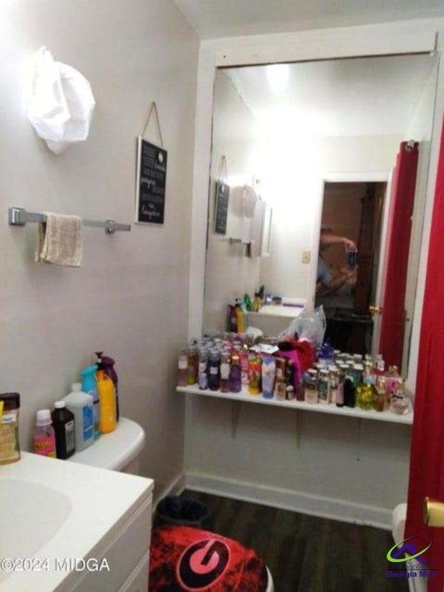 bathroom with vanity, toilet, and wood-type flooring