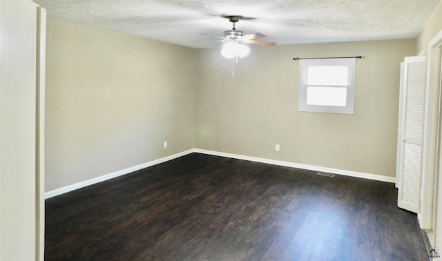 empty room featuring dark hardwood / wood-style flooring and a textured ceiling