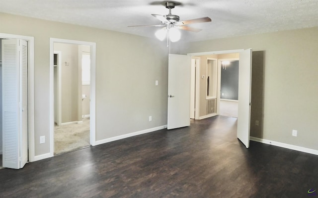 unfurnished bedroom with ceiling fan, dark hardwood / wood-style flooring, and a textured ceiling