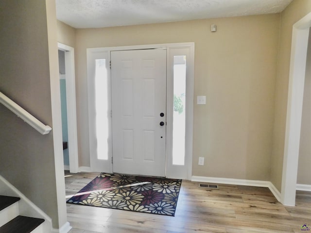 foyer featuring light hardwood / wood-style floors and a textured ceiling