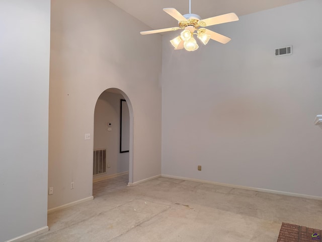 spare room with light carpet, high vaulted ceiling, and ceiling fan