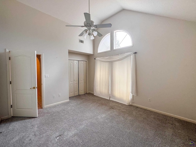 unfurnished bedroom featuring carpet flooring, a closet, vaulted ceiling, and ceiling fan