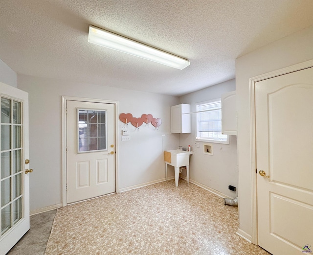 washroom with cabinets, washer hookup, and a textured ceiling