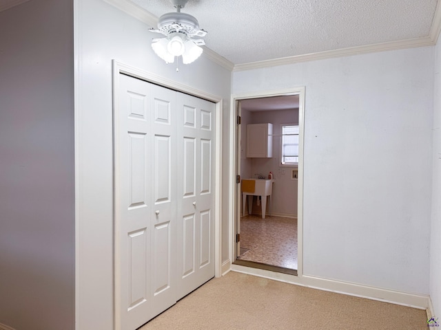 interior space featuring ceiling fan, a closet, a textured ceiling, and ornamental molding