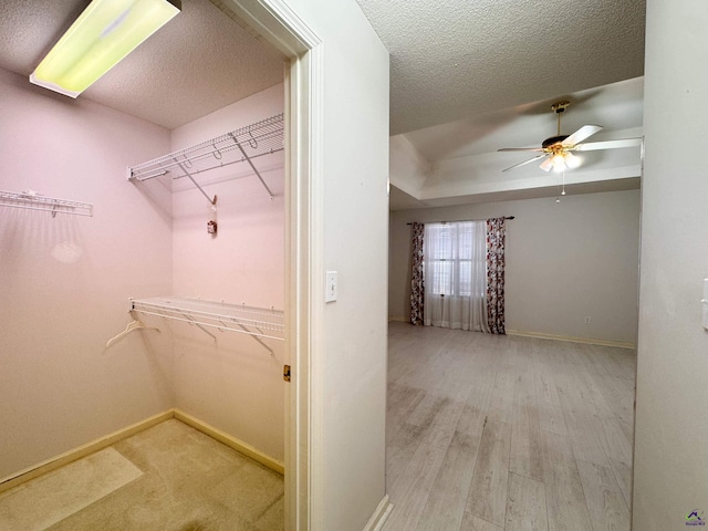 walk in closet featuring light wood-type flooring and ceiling fan