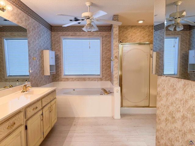 bathroom featuring vanity, ceiling fan, a textured ceiling, and plus walk in shower