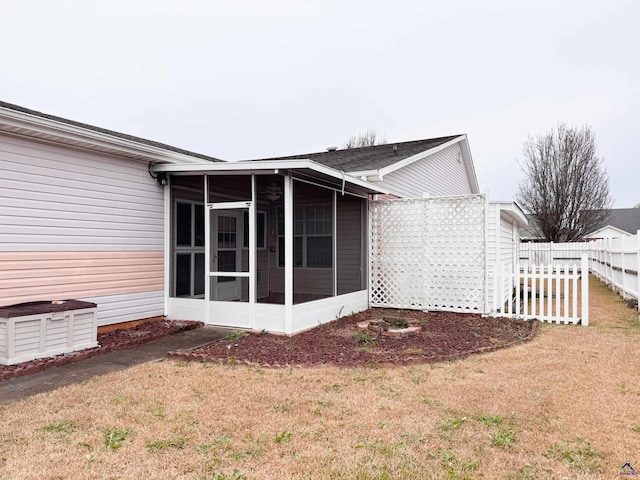 view of side of property with a lawn and a sunroom