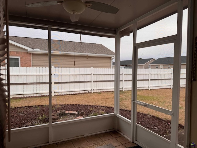 unfurnished sunroom with ceiling fan