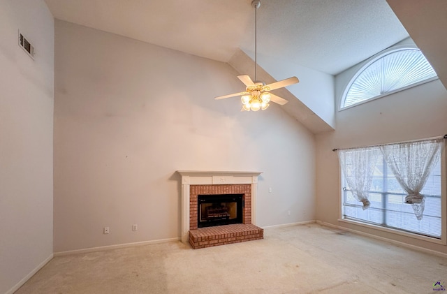 unfurnished living room with carpet, ceiling fan, a fireplace, and high vaulted ceiling