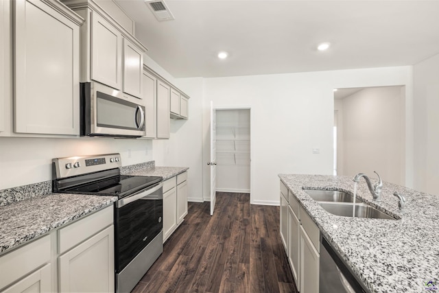 kitchen featuring light stone countertops, sink, dark hardwood / wood-style floors, and appliances with stainless steel finishes