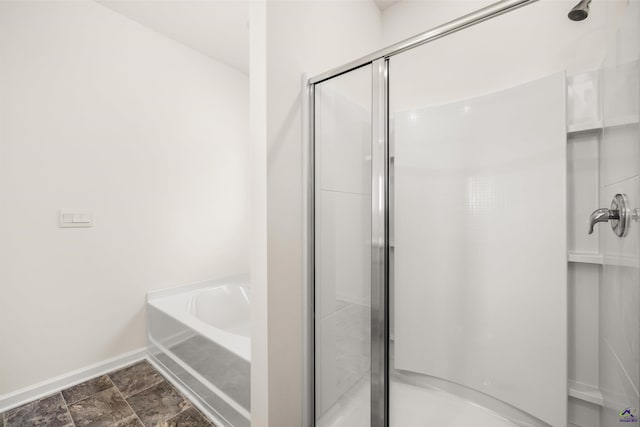 bathroom featuring shower with separate bathtub