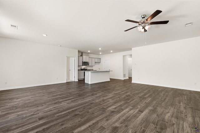 unfurnished living room featuring ceiling fan and dark hardwood / wood-style flooring