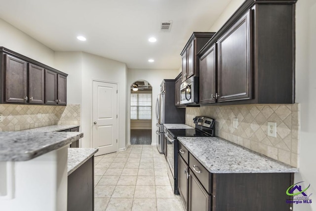 kitchen with decorative backsplash, light stone counters, black electric range, and ceiling fan