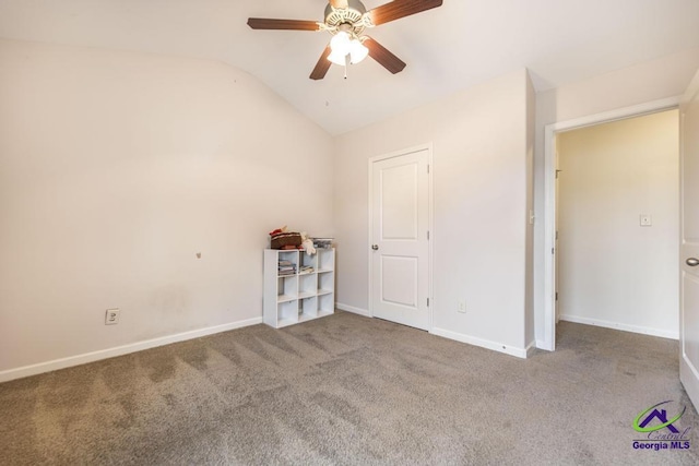 carpeted spare room featuring ceiling fan and lofted ceiling