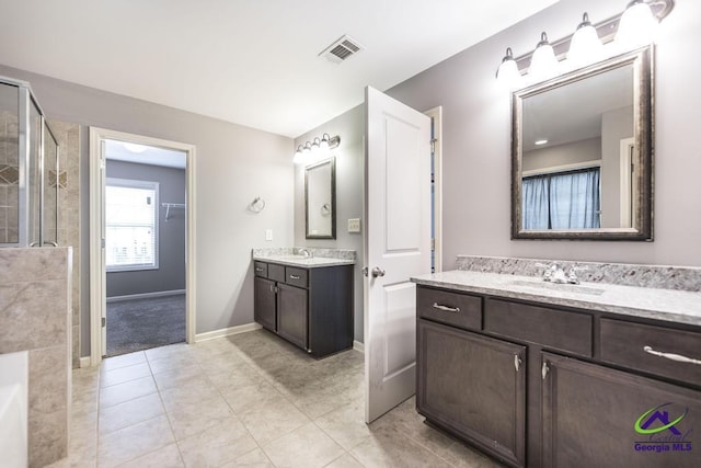 bathroom with tile patterned floors, vanity, and walk in shower