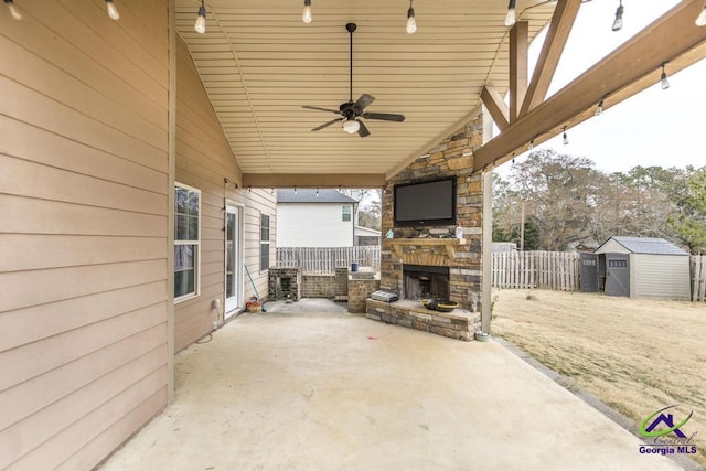 view of patio featuring an outdoor stone fireplace, ceiling fan, and a storage shed