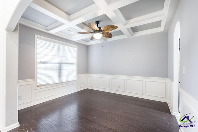 empty room featuring coffered ceiling, ceiling fan, ornamental molding, beam ceiling, and dark hardwood / wood-style flooring