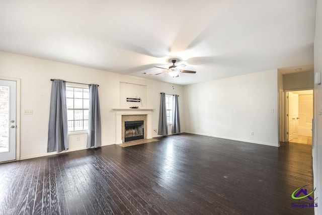 unfurnished living room featuring ceiling fan and dark hardwood / wood-style flooring